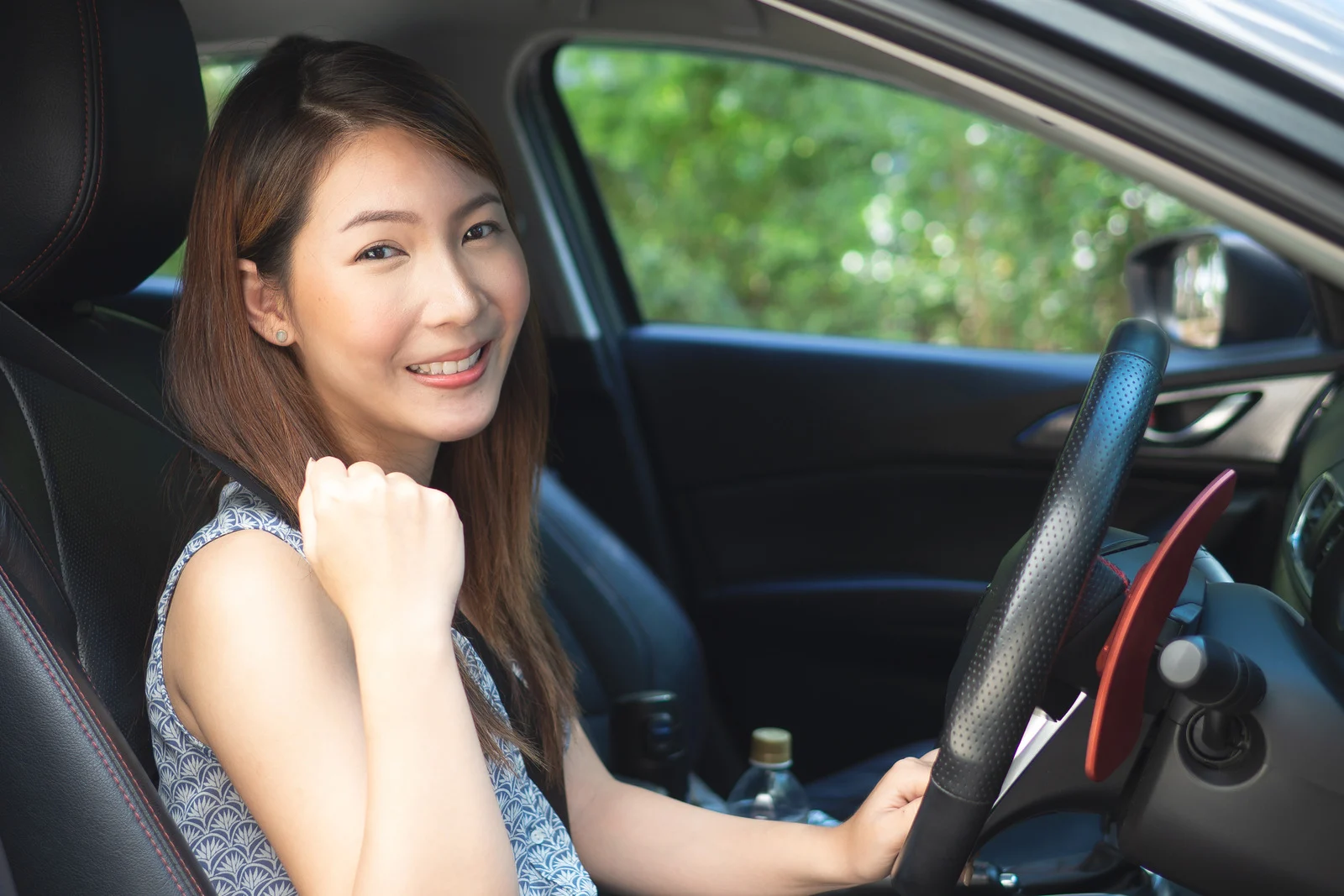 ผู้หญิงนั่งอยู่บนรถหน้าตายิ้มแย้มแจ่มใส